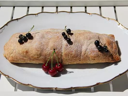 Puff-brumë roll me mollë, rrush të thatë dhe arra në çaj në një mbrëmje verore